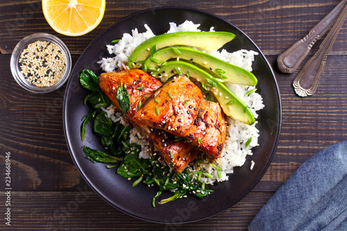 Salmon teriyaki rice bowl with spinach and avocado. View from above, top studio shot