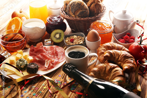 breakfast on table with bread buns, croissants, coffe and juice on new years eve