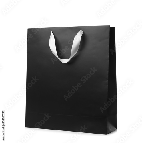 Paper shopping bag with ribbon handles on white background. Mockup for design
