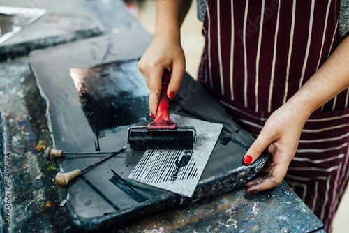 linocut. rolling paint on a piece of linoleum