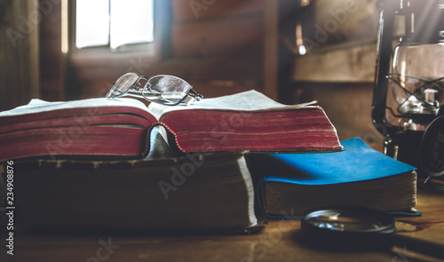 eyeglass on holy Bible with window light in morning.