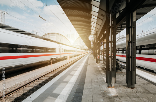 Bahn passiert Bahnhof bei blauem Himmel