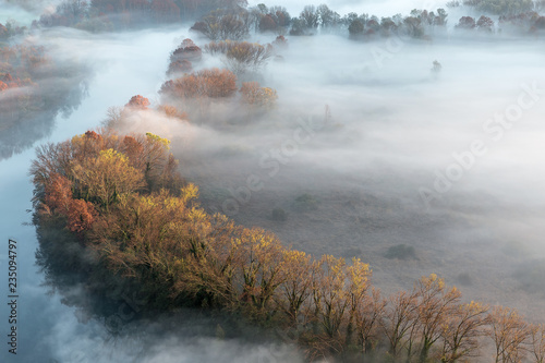 Panorama autunnale sul fiume con nebbia