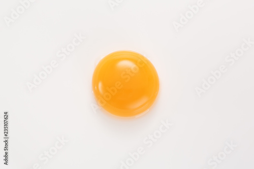Raw egg yolk on a white background. View from above.