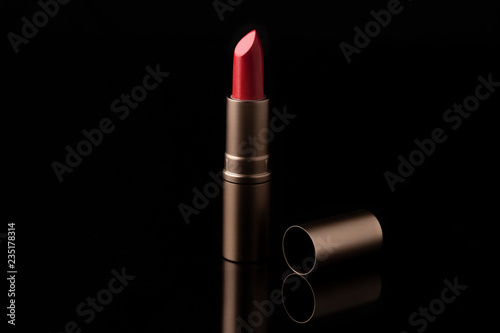 Luxury lipstick isolated on black background. Red lipstick.