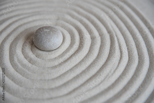 Gray zen stones on the sand with wave drawings. Concept of harmony, balance and meditation, spa, massage, relax