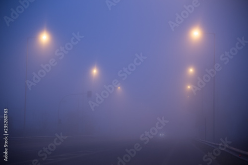 foggy road traffic lights in the morning , winter season