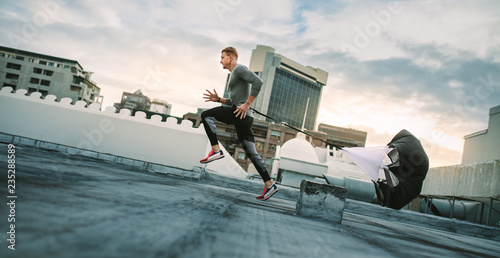 Athlete training on rooftop running with a resistance parachute