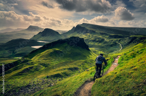 Mountain biker riding through rough mountain landscape of Quiraing, Scotland