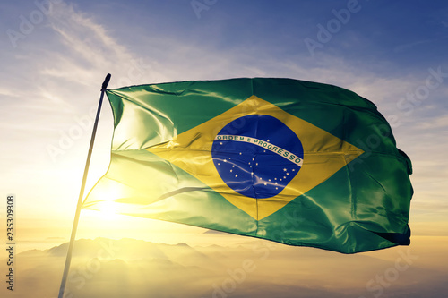 Brazil brazilian flag textile cloth fabric waving on the top sunrise mist fog