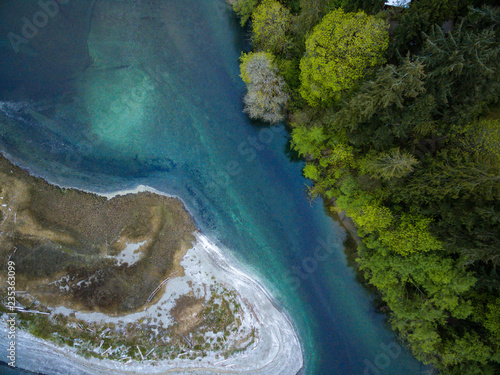 Aerial view looking down at the shoreline and beaches of an island along the turquoise sea of Puget Sound Washington