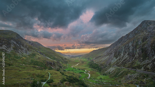 Beautiful dramatic landscape image of Nant Francon valley in Snowdonia during sunset in Autumn