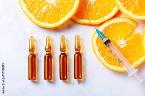 Vitamin C, natural anti aging cosmetics serum ampullas and syringe