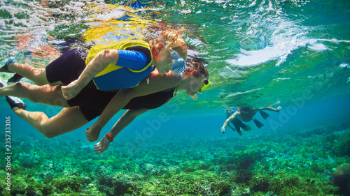 Happy family - father, mother, kids in snorkeling mask dive underwater with tropical fishes in coral reef sea pool. Travel lifestyle, watersport adventure, swimming on summer beach holiday with child.