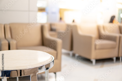 Table and sofa in waiting area of luxury hospital or hotel. Clinic interior background. Healthcare and medical concept. Focus on circle table.