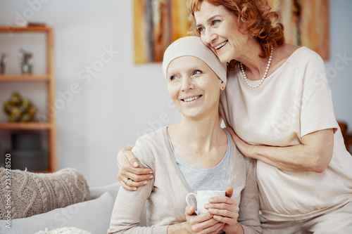 Two positive woman sitting together at home enjoining their time after radiation therapy