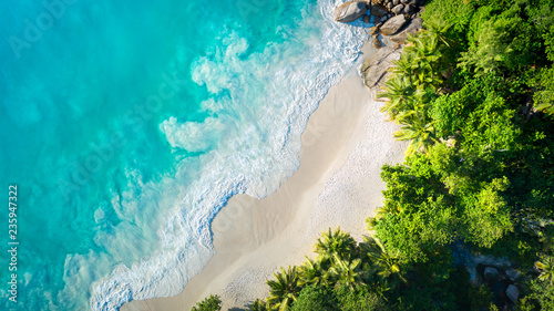 Tropical beach with sea and palm taken from drone. Anse Lazio beach at Praslin island, Seychelles. Vacation holidays concept