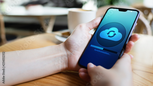 Mobile phone cloud synchronisation process on device screen. Technology concept.