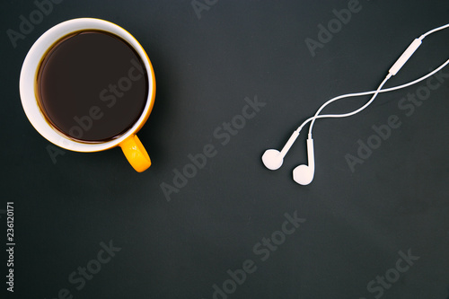 Coffee cup white music earphones dark background