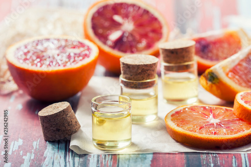 Essential oil citrus with orange slices, in glass bottle on old wooden table. Spa concept