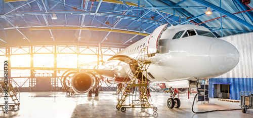 Maintenance and repair of aircraft in the aviation hangar of the airport, view of a wide panorama.