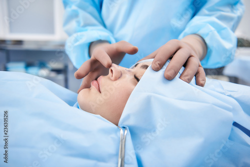 Doctor making rhinoplasty to lady. Surgeon palpating female patient nose