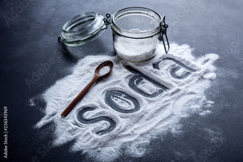baking soda scattered from a glass jar on a dark background