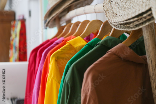  Variety of colorful shirts hanging on the wooden hangers, close up 