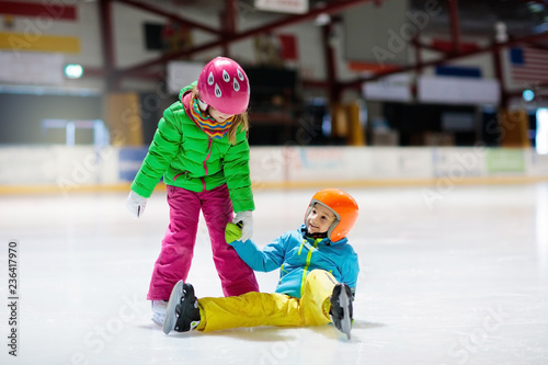 Child skating on indoor ice rink. Kids skate.