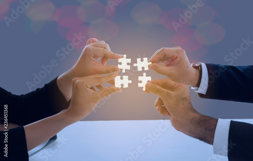 Image of businesswoman connecting elements of white puzzle