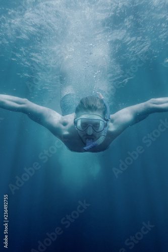 Young man diving underwater.