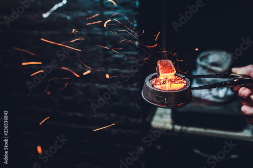 Shisha hookah with red hot coals. Sparks from breathe. Modern hookah with coconut charcoal for relax and shisha smoke. Hookah and sparks from coals. Another view. Shisha, spark,spark, hookah sparks.