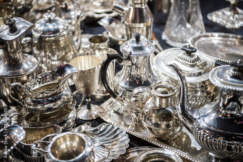 Shiny abstract background of antique silver tableware pieces in a full frame luxury jumble