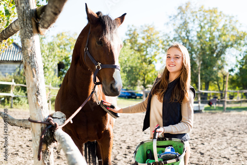 Girl equestrian rider equips horse. Horse theme 