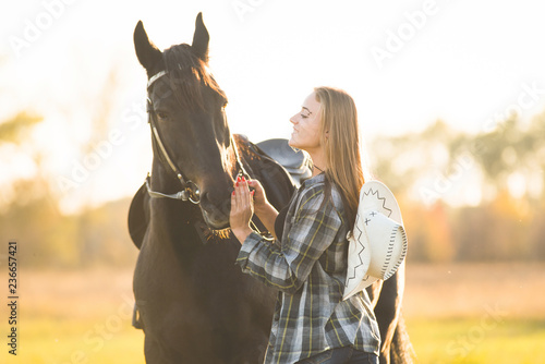 Girl equestrian rider stands near the horse. Horse farm. Horse theme 