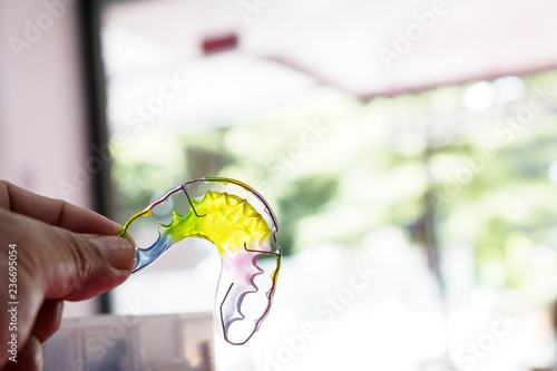 Dental retainer orthodontic appliance on the colour background.