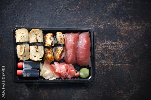Sushi. Tacka z kawałkami sushi , imbirem , wasabi i sosem sojowym na ciemnym tle.