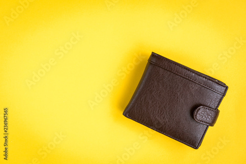 Brown men's wallet on yellow background.