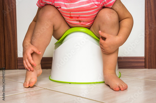 Child is sitting on baby potty