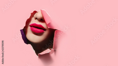 Beautiful red lips in pink paper frame. Plump lips, woman face. Close up portrait