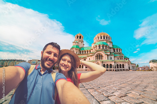 Happy couple travelling in Sofia, Bulgaria, taking photo selfie in front of the main cathedral