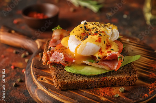 Tasty egg Benedict on wooden board