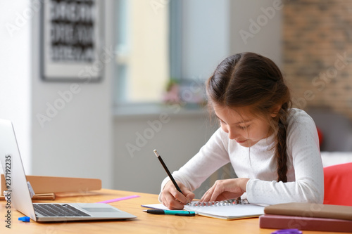 Cute girl doing homework at home