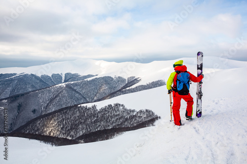 A skier is standing on the slope, watching the mountain scenery