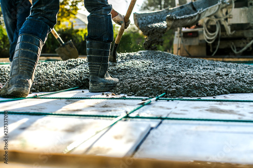 Mixer track pouring wet cement to the civil building foundation. Construction workers in the process of forming house concrete slab at the construction site.