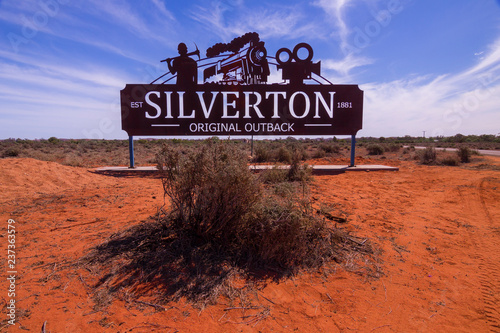 Silverton town welcome sign. Gateway to outback Australia with red desert sand and mulga bush.