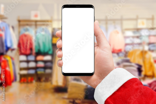 Santa Claus holding smartphone with empty screen in cloth store