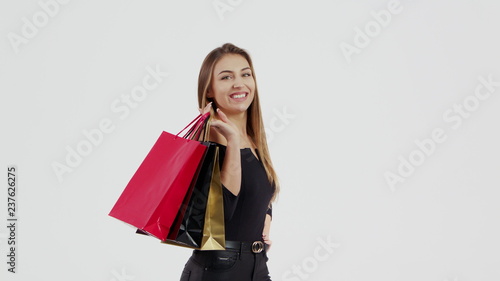 Woman in black dress, holding black, red and gold shopping bag isolated on white background in black friday holiday or christmas