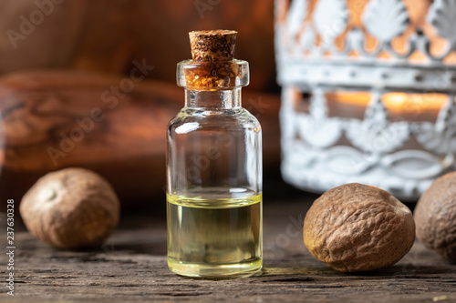 A bottle of nutmeg essential oil with nutmeg