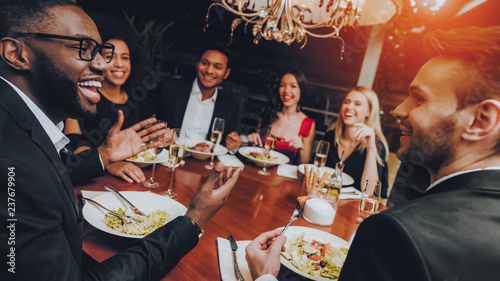 Group of Happy Friends Meeting and Having Dinner